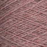 Close-up of a mini-cone spool of Jagger Brothers, Inc. JaggerSpun Heather 2/8 yarns in pink. The finely textured and densely wound yarn features various shades of pink, creating a pattern of intersecting lines and fibers. The image captures the intricate details, showcasing the use of low-impact synthetic dyes.