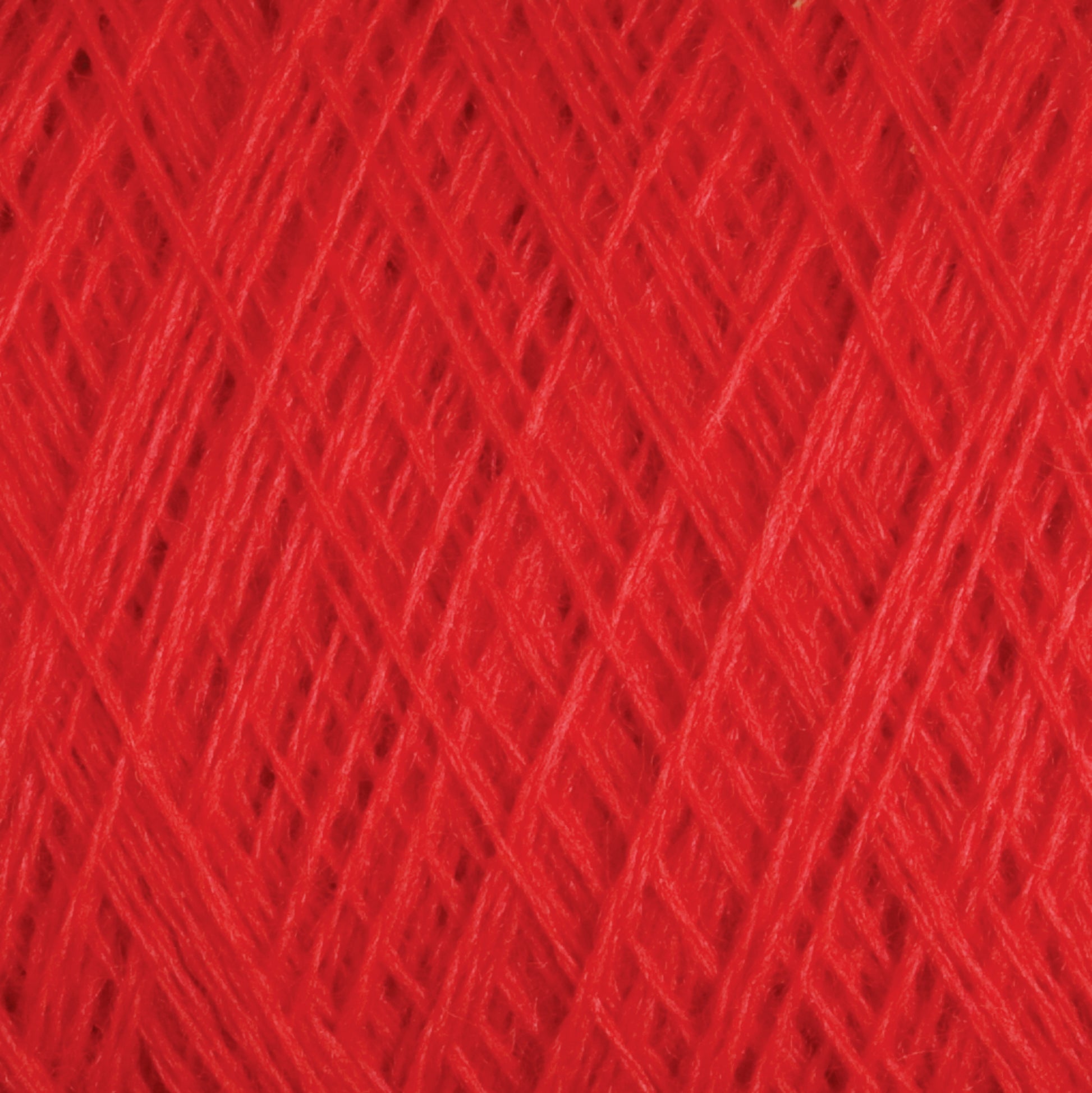 Close-up image of vibrant red JaggerSpun Superfine Merino 2/18 Yarn | Mini-cone by Jagger Brothers, Inc., showcasing a crisscross pattern of tightly wound fibers. The texture appears soft, with fine threads intricately interwoven to form a solid and consistent surface.