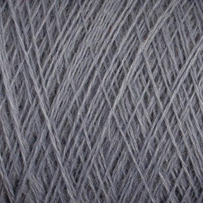 Close-up image of the JaggerSpun Superfine Merino 2/18 Yarn | Mini-cone by Jagger Brothers, Inc. The light gray threads are tightly wound together, showcasing intricate texture and pattern. The light captures the soft fibers, emphasizing the smooth and delicate texture of this hand knitters yarn.