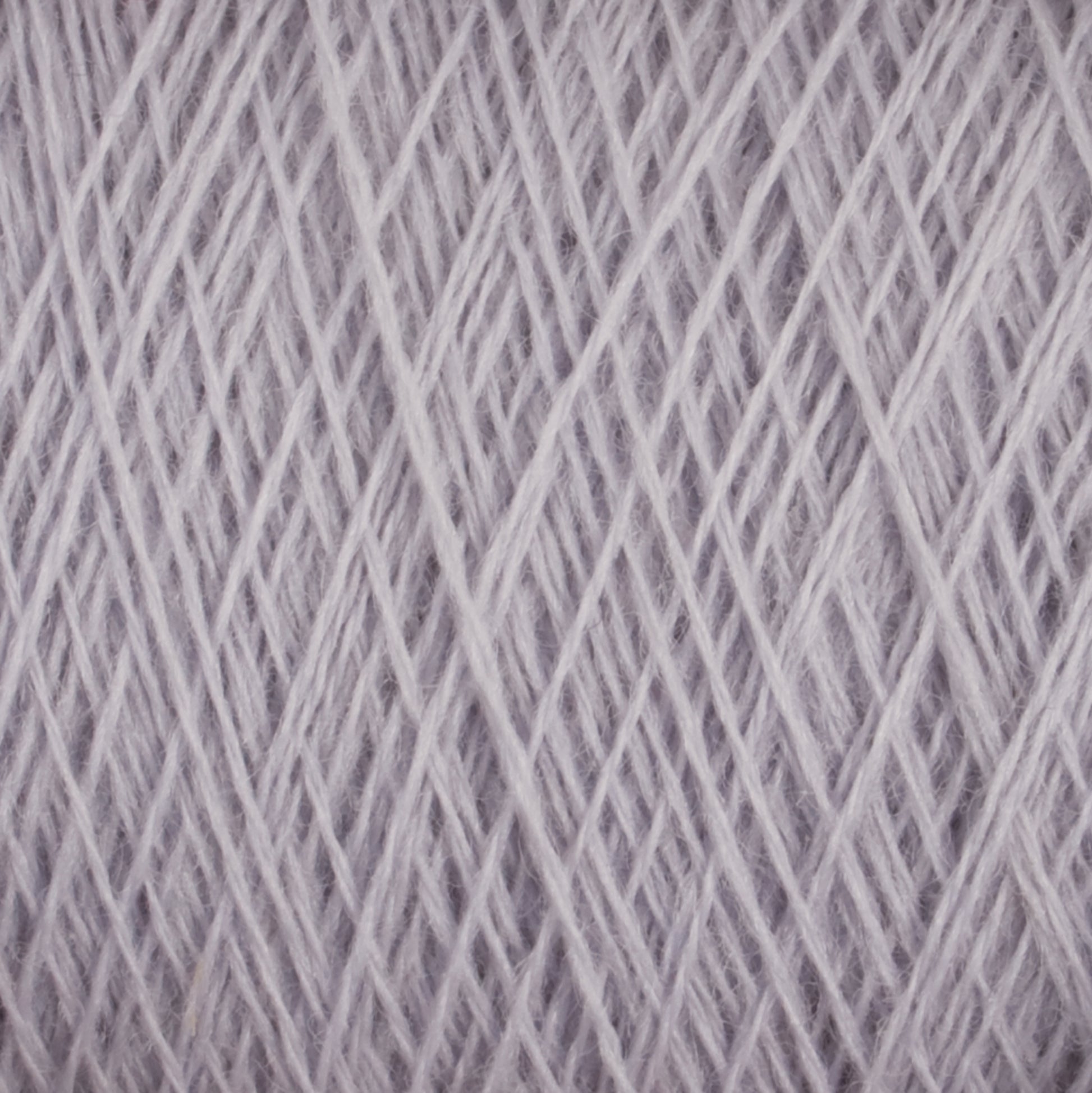 Close-up image of a spool of Jagger Brothers, Inc.'s JaggerSpun Superfine Merino 2/18 Yarn | Large Cone in light grey. The yarn is dense, with numerous intersecting strands crisscrossing in various directions, creating a textured and intricate pattern perfect for hand knitters. This worsted weight merino wool is ideal for crafting cozy garments and accessories.