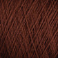 Close-up view of JaggerSpun Superfine Merino 2/18 Yarn | Mini-cone by Jagger Brothers, Inc., wound tightly in a crisscross pattern. The texture of the yarn fibers is clearly visible, highlighting the soft and slightly fuzzy nature of the dark brown Merino wool material.