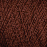 Close-up view of JaggerSpun Superfine Merino 2/18 Yarn | Mini-cone by Jagger Brothers, Inc., wound tightly in a crisscross pattern. The texture of the yarn fibers is clearly visible, highlighting the soft and slightly fuzzy nature of the dark brown Merino wool material.