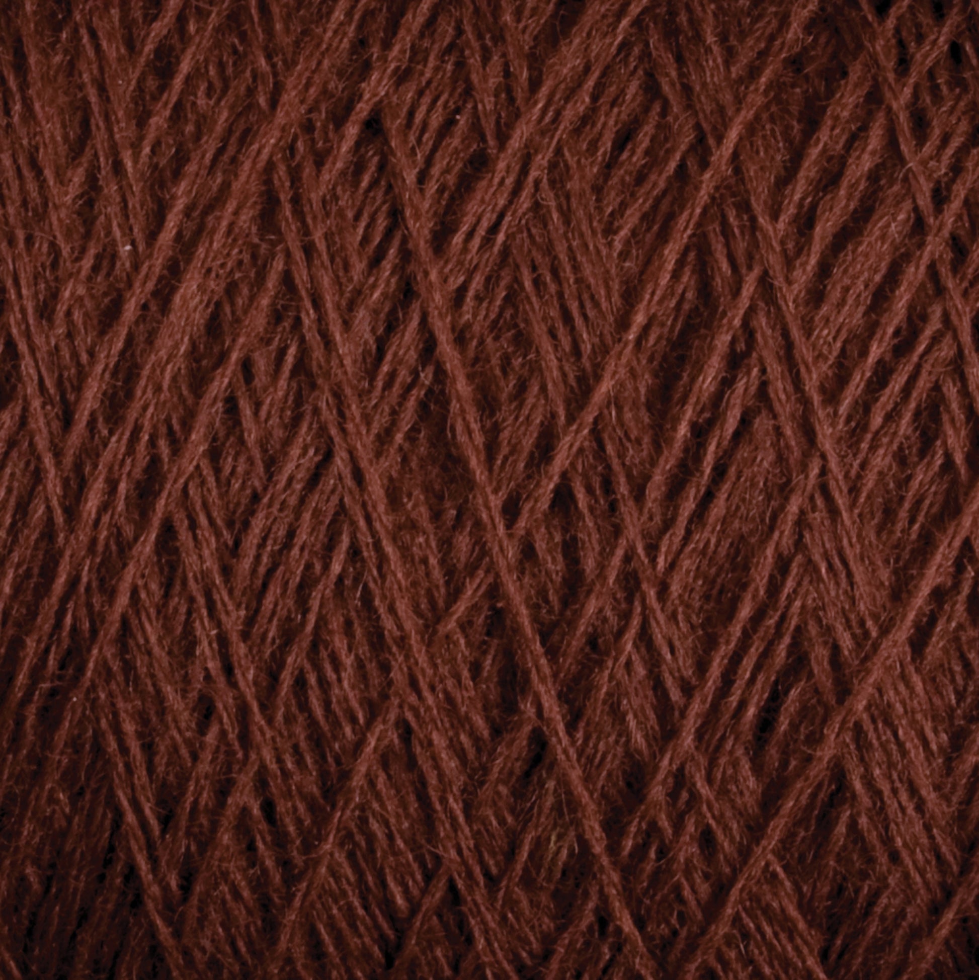 Close-up view of JaggerSpun Superfine Merino 2/18 Yarn | Mini-cone by Jagger Brothers, Inc., wound tightly in a crisscross pattern. The texture of the yarn fibers is clearly visible, highlighting the soft and slightly fuzzy nature of the dark brown Merino wool material.