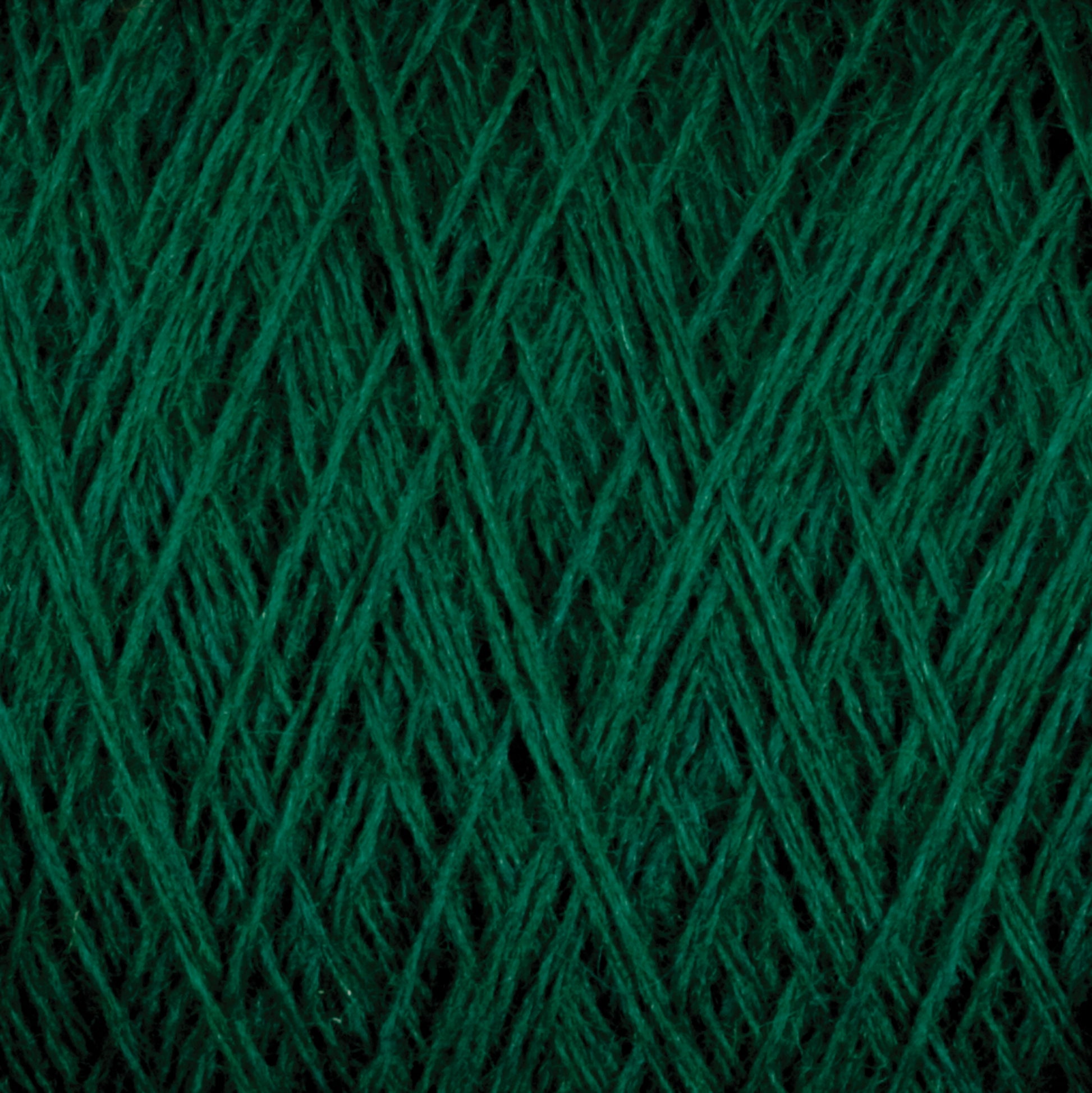 Close-up of dark green JaggerSpun Superfine Merino 2/18 Yarn from Jagger Brothers, Inc. tightly wound in a crisscross pattern, highlighting the texture and fibers.