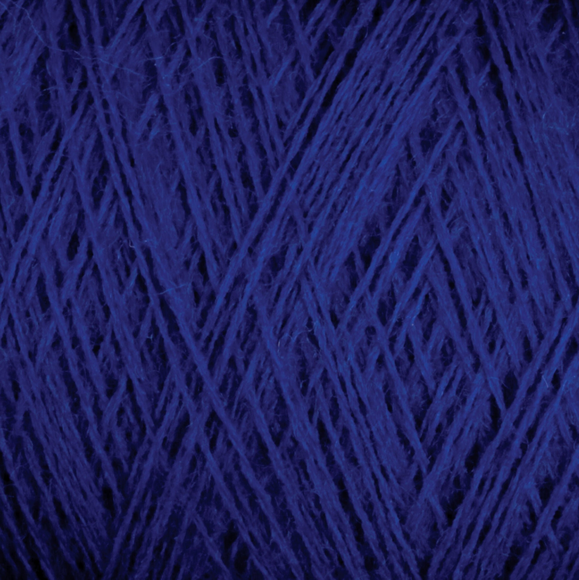 A close-up image of Jagger Brothers, Inc.'s JaggerSpun Superfine Merino 2/18 Yarn (Mini-cone) in dark blue. The tightly wound strands create a textured, overlapping pattern with clearly visible fibers, giving the image a rich and intricate appearance ideal for hand knitters.