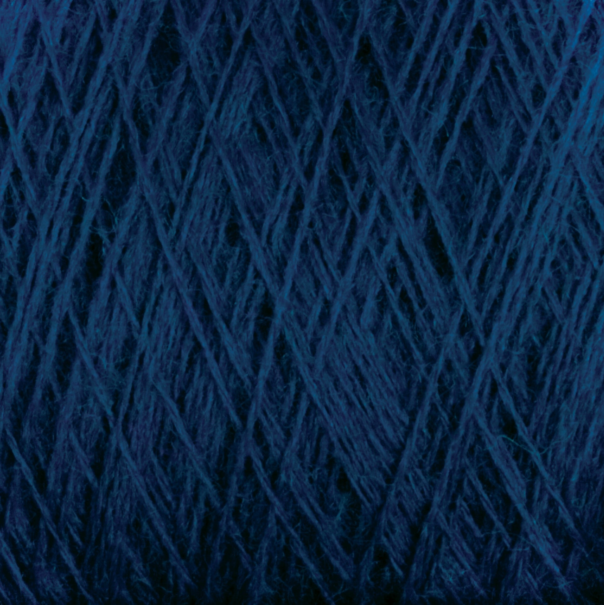 Close-up view of dark blue JaggerSpun Superfine Merino 2/18 Yarn | Mini-cone available from Jagger Brothers, Inc., wound tightly into a ball. The yarn strands create a criss-cross pattern, showcasing various shades of blue. The texture appears soft and slightly fuzzy, typical of high-quality Merino wool yarn.