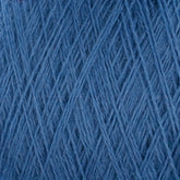 Close-up image of a ball of blue JaggerSpun Superfine Merino 2/18 Yarn | Mini-cone by Jagger Brothers, Inc. The strands are tightly interwoven, creating a textured pattern that highlights the softness and fibrous quality of the yarn. The color is a consistent shade of medium blue.