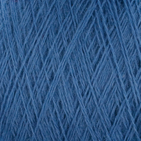 Close-up image of a ball of blue JaggerSpun Superfine Merino 2/18 Yarn | Mini-cone by Jagger Brothers, Inc. The strands are tightly interwoven, creating a textured pattern that highlights the softness and fibrous quality of the yarn. The color is a consistent shade of medium blue.