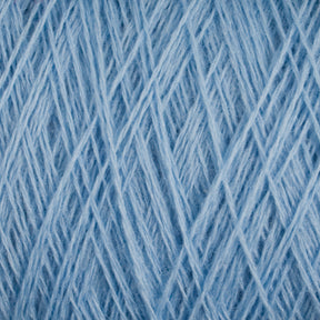 Close-up view of a ball of JaggerSpun Superfine Merino 2/18 Yarn in light blue from Jagger Brothers, Inc., showcasing its soft, fuzzy texture. The worsted weight fibers crisscross and intertwine in various directions, creating a detailed and intricate pattern perfect for hand knitters.