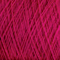 Close-up image of a ball of bright pink JaggerSpun Superfine Merino 2/18 Yarn from Jagger Brothers, Inc., with threads woven tightly together forming a crisscross pattern. The texture appears soft and slightly fuzzy, indicating the yarn is made of superfine Merino wool.