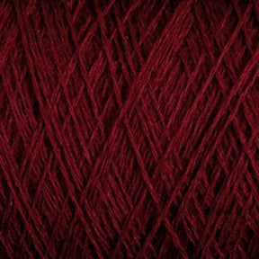 Close-up view of a tightly wound ball of deep red JaggerSpun Superfine Merino 2/18 Yarn from Jagger Brothers, Inc. The threads are intricately interwoven, creating a textured pattern with varying shades of red due to the light and shadow. The image emphasizes the fibrous and detailed nature of this hand knitters yarn.