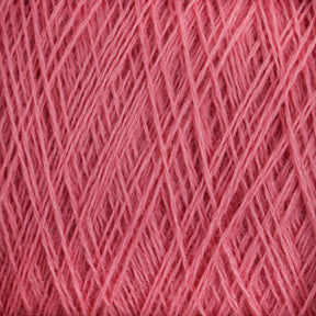 Close-up of a tightly wound spool of JaggerSpun Superfine Merino 2/18 Yarn in a soft pink hue. The finely textured fibers, crafted by Jagger Brothers, Inc., are neatly arranged, creating an intricate and uniform pattern. Soft and ideal for hand knitters, this worsted weight yarn is perfect for knitting or crochet projects.