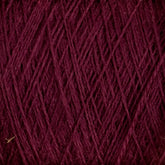 Close-up of the JaggerSpun Superfine Merino 2/18 Yarn | Mini-cone in burgundy, revealing a crisscross pattern. The image displays the texture and details of the tightly woven strands, with the rich, dark red color dominating the view. Ideal for hand knitters, this worsted spun yarn from Jagger Brothers, Inc. offers both beauty and durability.