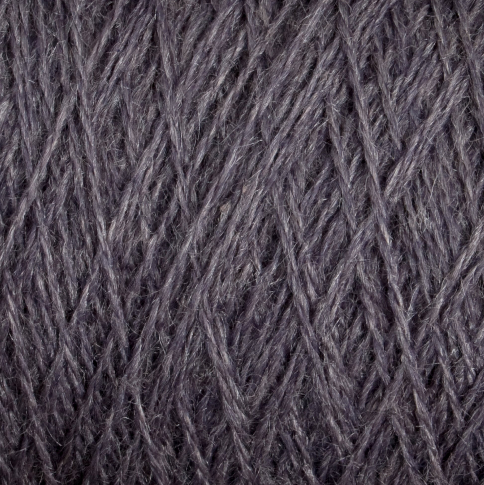 Close-up of a textured surface showing tightly woven, dark gray yarn. The intricate crisscross pattern and soft fibers are clearly visible, highlighting the detailed craftsmanship and material quality of this luxurious JaggerSpun Zephyr Wool-Silk 2/18 Yarn from Jagger Brothers, Inc.