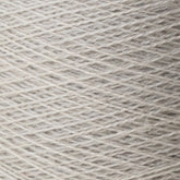 Close-up image of a spool of Jagger Brothers, Inc.'s JaggerSpun Zephyr Wool-Silk 2/18 Yarn in light gray. The fibers, made from luxurious Australian merino wool blended with silk, are tightly wound in a crisscross pattern, showcasing the texture and slight variations in color.