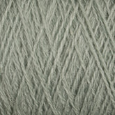 Close-up of a ball of luxurious light gray-green JaggerSpun Zephyr Wool-Silk 2/18 Yarn from Jagger Brothers, Inc., showcasing its soft, intertwined fibers. The yarn appears well-wound on the large cone, with a slightly fuzzy texture, perfect for knitting or crocheting projects.