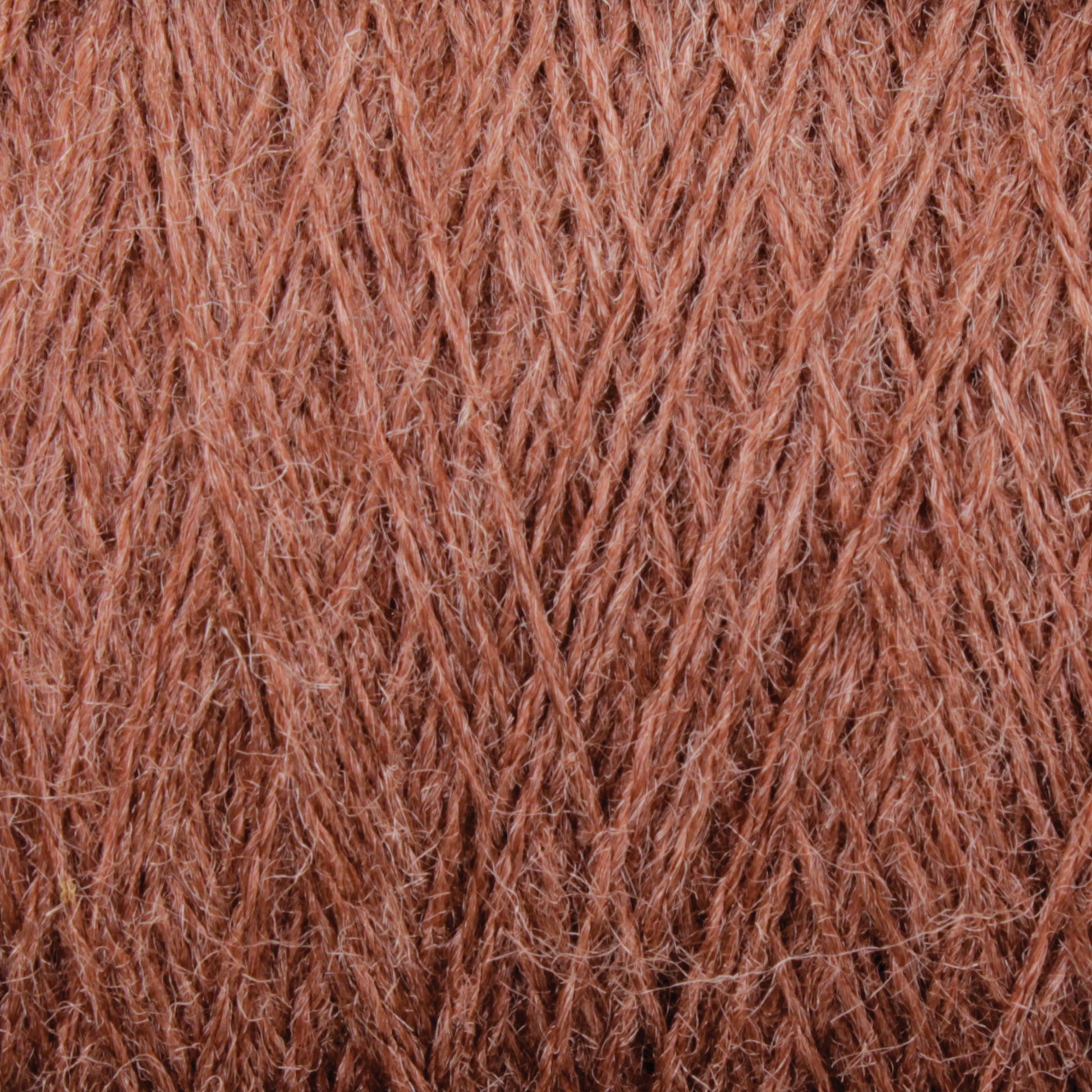 A close-up image of light brown JaggerSpun Zephyr Wool-Silk 2/18 Yarn by Jagger Brothers, Inc., showcasing its soft and fibrous texture. The image highlights the intricate weave pattern and individual fibers, emphasizing the material's warmth and fluffiness, embodying the elegance of luxurious yarn crafted from a blend of Australian merino wool and silk.