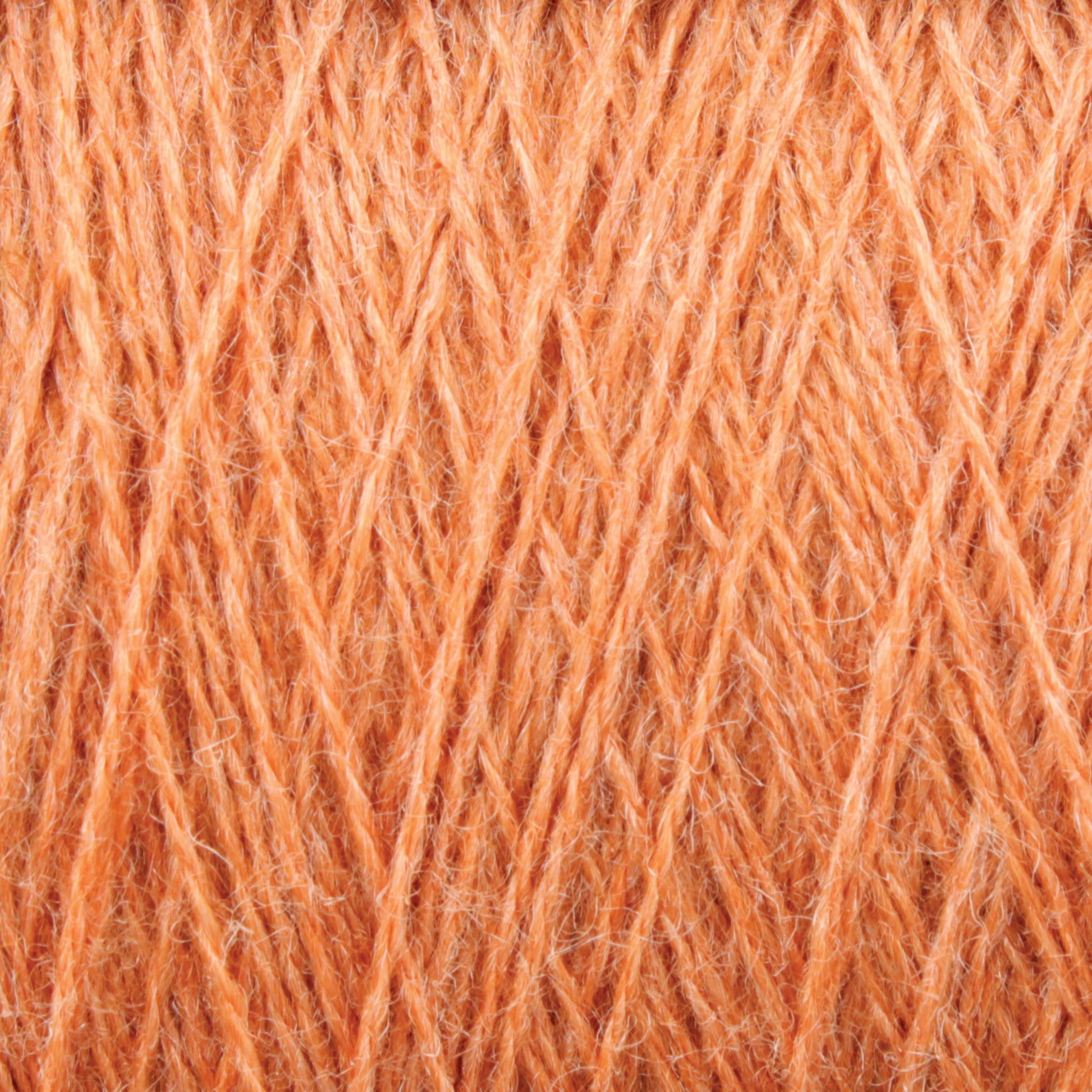 Close-up image of a textured ball of thick orange JaggerSpun Zephyr Wool-Silk 2/18 Yarn from Jagger Brothers, Inc. The fibers, made from luxurious Australian superfine merino wool blended with silk, are intertwined and slightly fuzzy, creating an intricate pattern with visible details of the threading and material.