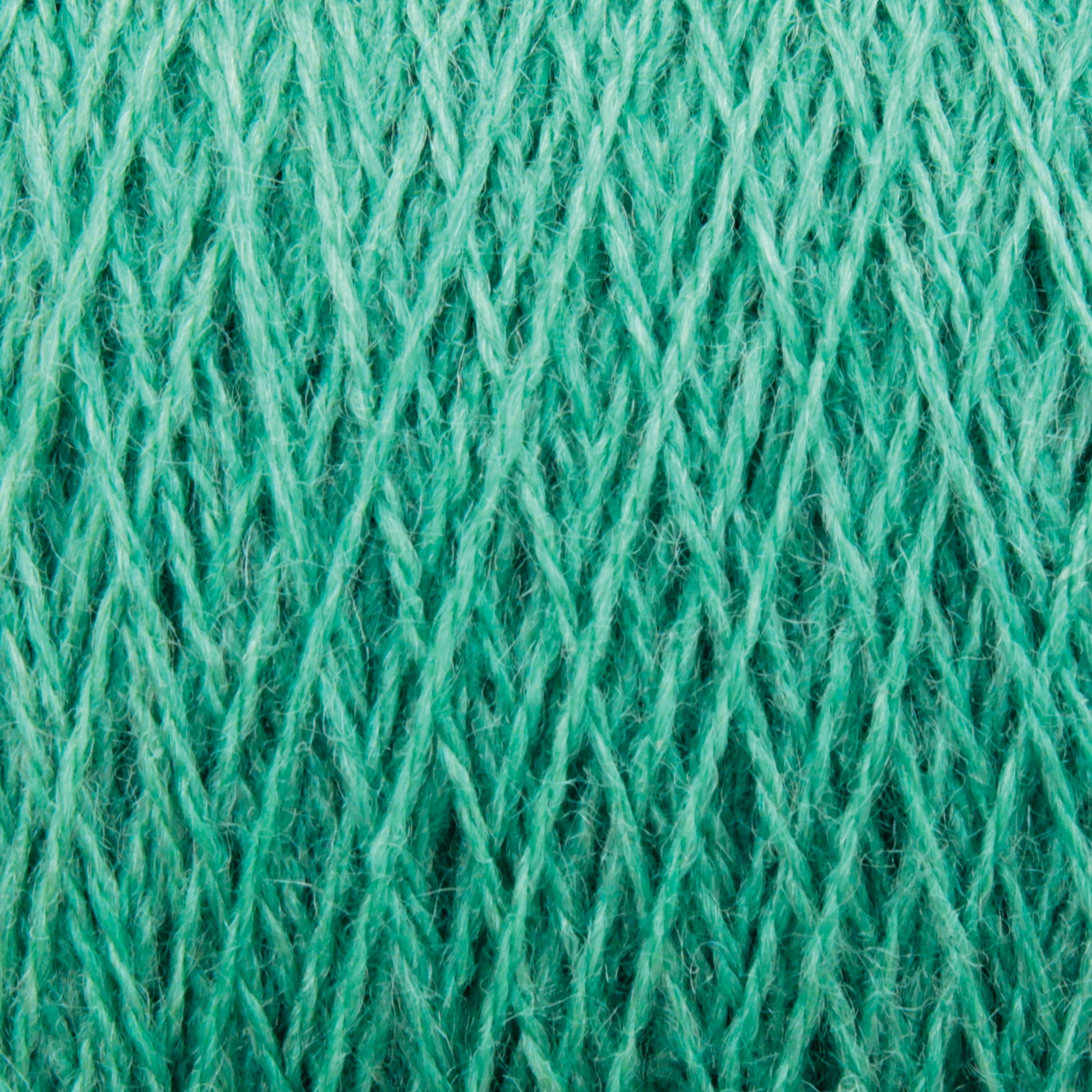 Close-up of JaggerSpun Zephyr Wool-Silk 2/18 Yarn in turquoise, showcasing interwoven fibers and intricate cross-hatch patterning. The slightly fuzzy strands emphasize the softness of this luxurious yarn, crafted by Jagger Brothers, Inc. from a blend of superfine merino wool and silk. The color is vibrant and evenly distributed throughout the fibers.