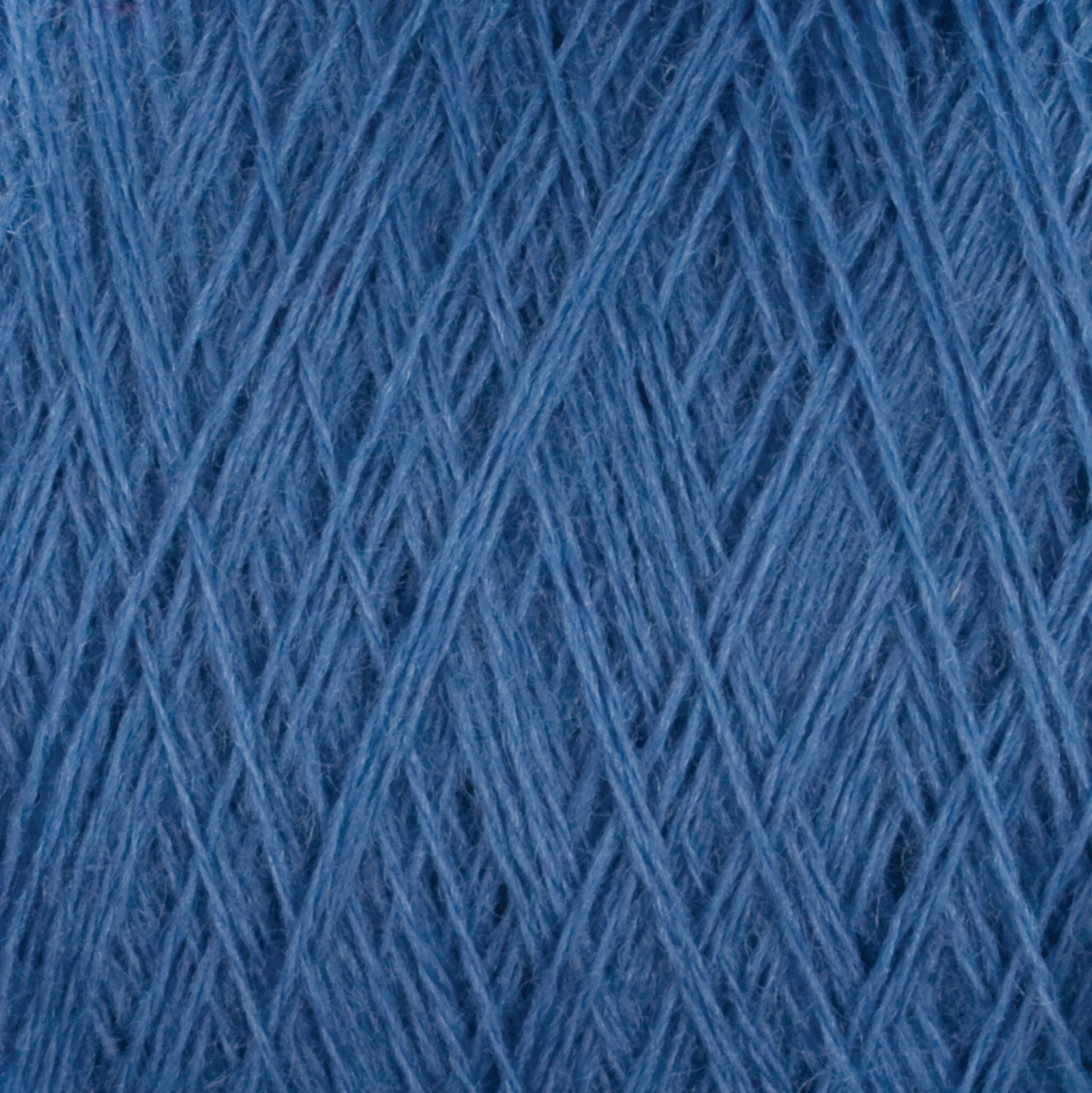 Close-up image of JaggerSpun Zephyr Wool-Silk 2/18 Yarn | Mini-cone by Jagger Brothers, Inc. The texture shows fine threads tightly wound together, forming a soft, smooth, and uniform surface suitable for knitting or crocheting. The shade of blue appears consistent throughout the image with no visual imperfections or variations.