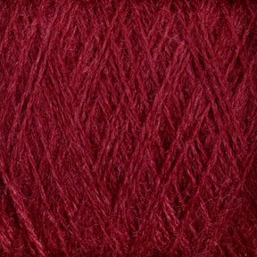 Close-up image of a mini-cone of JaggerSpun Zephyr Wool-Silk 2/18 Yarn by Jagger Brothers, Inc., showcasing the detailed texture of its maroon-colored fibers arranged in a crisscrossing pattern. The yarn appears soft and slightly fuzzy, with intricate interwoven strands that highlight its luxurious blend of premium silk and Australian superfine merino wool.