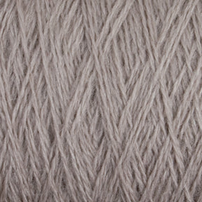 Close-up of JaggerSpun Zephyr Wool-Silk 2/18 Yarn wound into a tight ball, showing detailed texture and individual threads. The light beige fibers exhibit a soft, slightly fuzzy appearance with a crisscross pattern formed by the overlapping strands. This luxurious yarn from Jagger Brothers, Inc. combines Australian merino wool with premium silk for an exquisite finish.