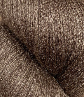 Close-up image of Jagger Brothers, Inc.'s JaggerSpun Zephyr Wool-Silk 2/18 Yarn | Large Cone. The luxurious yarn has a slightly shiny appearance and a dense interwoven pattern, showcasing its soft and fibrous nature.