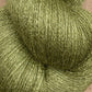 A close-up view of a skein of light olive green JaggerSpun Zephyr Wool-Silk 2/18 Yarn from Jagger Brothers, Inc., showcasing its luxurious, soft, and slightly fuzzy texture.