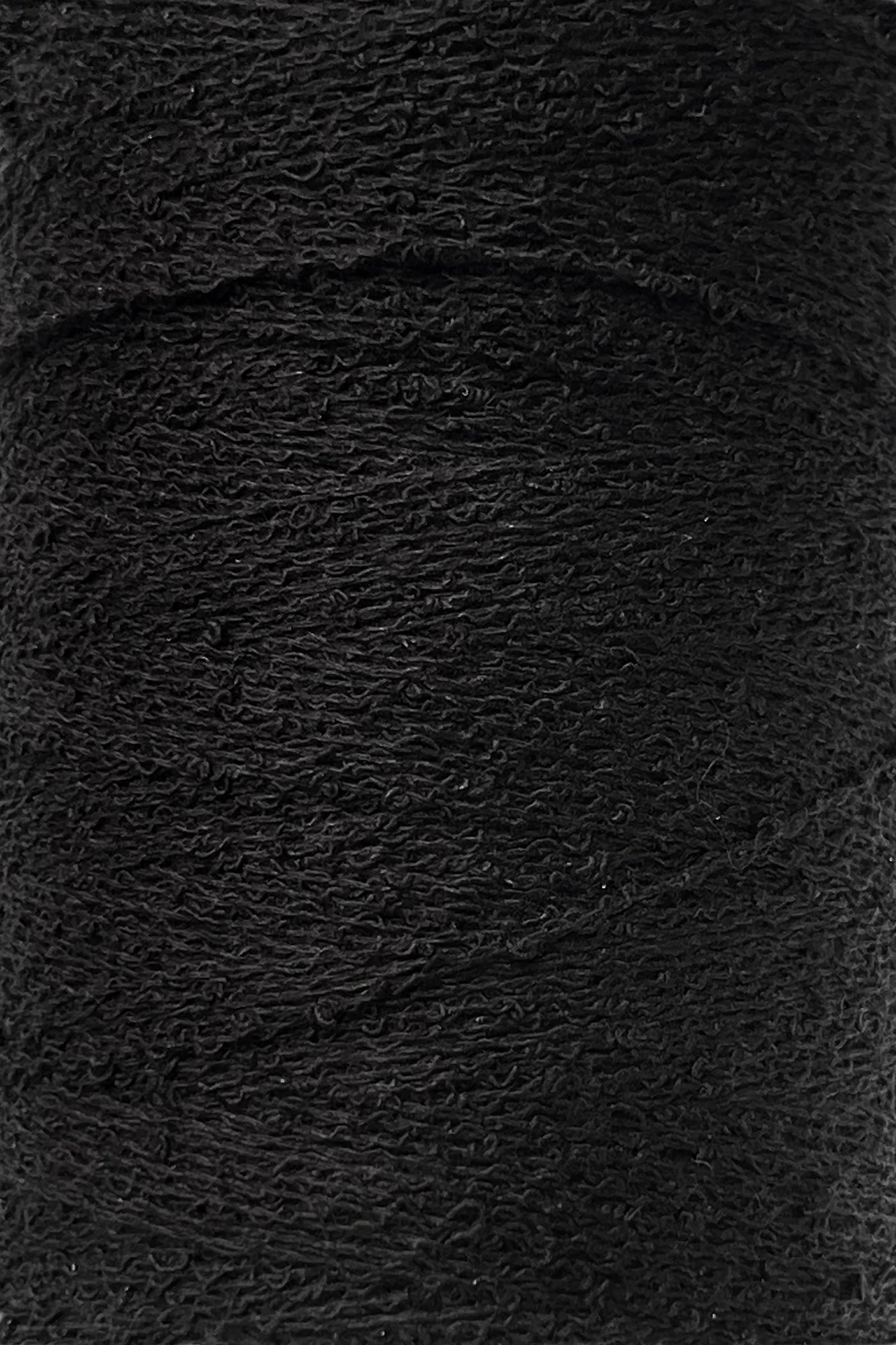 A close-up of a spool of Maurice Brassard's Cotton Bouclé Yarn in black, showcasing its texture and tightly wound fibers. The yarn appears slightly fuzzy, indicating a soft cotton material. The image highlights the uniformity and consistency of the winding, making it perfect for weaving projects.