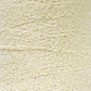 A close-up image of a large spool of cream-colored yarn. The yarn texture appears soft and slightly twisted, with visible fibers intertwined uniformly throughout the spool. Featuring what appears to be Cotton Bouclé Yarn in a Tube by Maurice Brassard, the image captures the intricate details and smoothness of the yarn's surface.