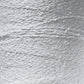 Close-up of a textured gray surface with a wavy, uneven pattern, resembling crumpled aluminum foil or a heavily textured metallic material. The surface appears slightly reflective and has a metallic sheen, reminiscent of the intricate detail found in Maurice Brassard's Cotton Bouclé Yarn.