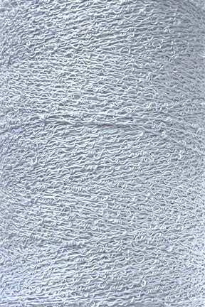 Close-up image of a spool of Maurice Brassard's Cotton Bouclé Yarn. The white thread appears tightly wound, showcasing a slightly textured, curly pattern characteristic of Cotton Bouclé. The overall impression is clean and uniform with a smooth yet intricate surface.