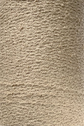 Close-up of a large spool of Maurice Brassard's Cotton Bouclé Yarn. The tightly wound, beige yarn exhibits a slightly rough, uneven texture indicative of natural fiber. The uniform color and distinct texture make it well-suited for knitting or weaving projects.