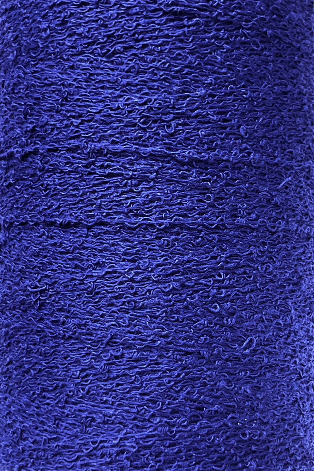 Close-up texture of a roll of Maurice Brassard Cotton Bouclé Yarn | Tube. The yarn appears tightly wound with visible fibers and a slightly rough surface, showcasing a rich, vibrant blue hue ideal for weaving cotton projects.