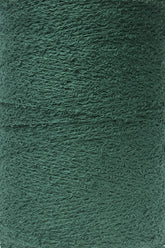 A close-up view of Maurice Brassard's Cotton Bouclé Yarn | Tube in a rich, deep green shade. This yarn features a textured, slightly fuzzy surface with visible twists and fibers.