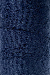 Close-up image of a spool of Maurice Brassard's Cotton Bouclé Yarn in dark navy blue. The texture of the yarn is clearly visible, showcasing a tightly wound, slightly uneven surface. This creation appears thick and sturdy, perfect for intricate weaving projects.