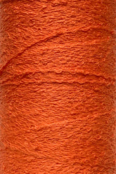 Close-up of a bright orange spool of Cotton Bouclé Yarn | Tube from Maurice Brassard, featuring a rough texture. This tightly wound yarn, ideal for weaving cotton projects, highlights its fibrous details and rich color reminiscent of those from the esteemed Maurice Brassard collections.