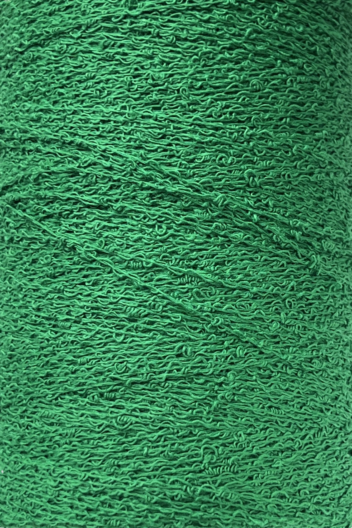 Close-up image of a spool of bright green Maurice Brassard Cotton Bouclé Yarn. The texture of the thread is visible, with intricate patterns and slight irregularities in the strands, creating a detailed and tactile effect. The color is vibrant and consistent throughout the spool.