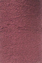 Close-up shot of a large cone of maroon-colored Maurice Brassard Cotton Bouclé Yarn. The yarn appears to be tightly wound with a slightly rough surface, and the fibers have a uniform color with a texture that hints at a blend of materials.