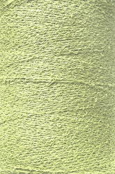 Close-up image of a spool of Maurice Brassard's Cotton Bouclé Yarn in light green. The yarn has a slightly uneven and loopy texture, reminiscent of classic bouclé, creating an intricate pattern across the surface of the tube.