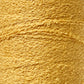 Close-up of a textured spool of Maurice Brassard's Cotton Bouclé Yarn in a golden-yellow hue, showcasing its rough and wavy fibers tightly wrapped around itself. The weaving yarn's slightly uneven surface lends it a rich, tactile quality.