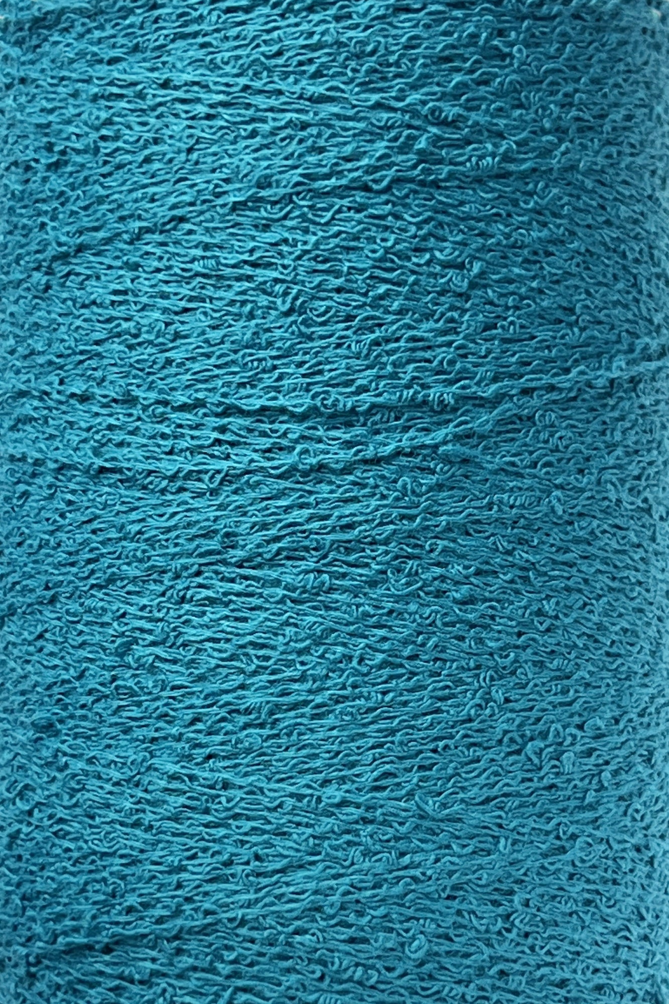 Close-up of a turquoise textured surface showing intricate patterns of thread or fibers, likely from Maurice Brassard's Cotton Bouclé Yarn. The surface exhibits a tightly woven, slightly rough texture with subtle variations in color due to the weave, reminiscent of premium Cotton Bouclé.