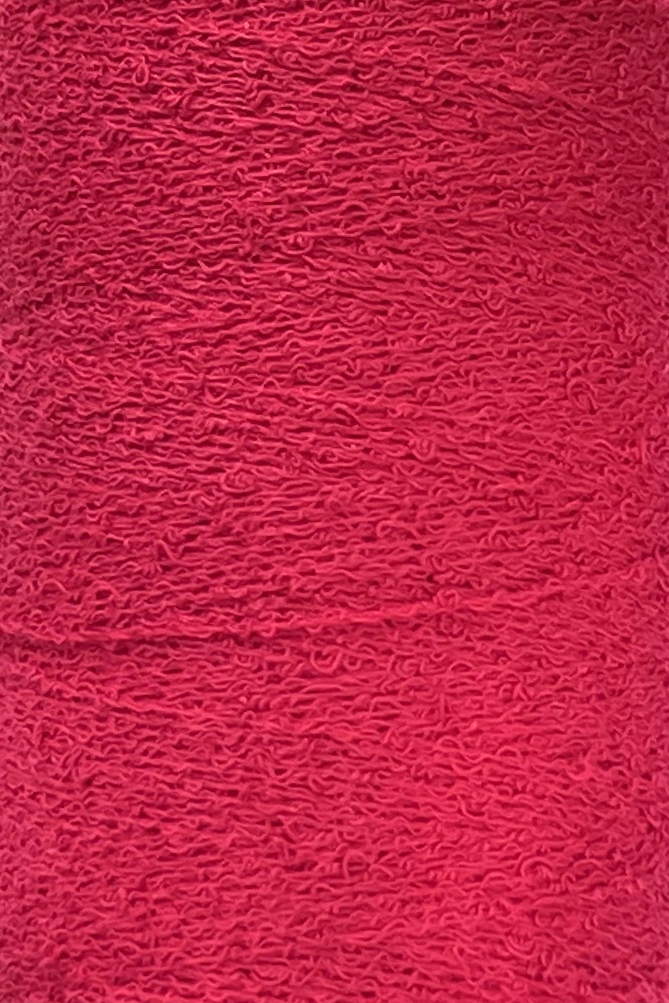 Close-up image of a textured surface in a deep red color. The texture, resembling Maurice Brassard's Cotton Bouclé Yarn | Tube, features numerous small, swirling patterns that give it a slightly rough and intricate appearance. Perfect for weaving cotton enthusiasts seeking unique fabric details.