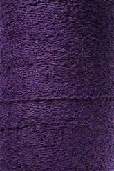 Close-up shot of a tightly wound spool of Maurice Brassard's Cotton Bouclé Yarn in purple. The slightly rough surface of this weaving yarn appears dense, with layers stacked consistently in a continuous pattern.