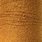 Close-up of a textured, golden-brown fabric roll. The fabric, woven with 100% Cotton Bouclé Yarn | Mini-Cone from Maurice Brassard, features tightly interwoven threads creating intricate patterns with a tactile and slightly rough surface. The color is consistent throughout, emphasizing the detailed craftsmanship.