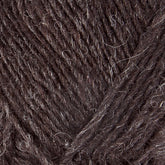 Close-up view of Léttlopi (Lite Lopi) Icelandic Wool Yarn by Berroco, Inc., showcasing a rich, textured dark brown yarn with interspersed lighter fibers. The fibers have a soft and slightly fuzzy appearance, indicating the material's coziness and suitability for colorwork knitting warm garments. This yarn is perfect for creating durable pieces with an authentic Icelandic wool feel.