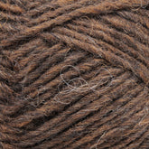 Close-up image of Léttlopi (Lite Lopi) Icelandic Wool Yarn by Berroco, Inc. in dark brown and grayish hues. The coarse texture with some loosely woven fibers visible suggests a blend of natural materials ideal for colorwork knitting.