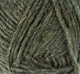 Close-up of a ball of Léttlopi (Lite Lopi) Icelandic Wool Yarn by Berroco, Inc., showcasing the intricate detail of the fibers and strands wrapped around each other. This yarn, perfect for creating durable garments and intricate colorwork knitting, features a blend of lighter and darker green hues that give it a textured and slightly fuzzy appearance.