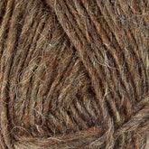 Close-up of brown and green Léttlopi Icelandic wool yarn by Berroco, Inc. The fibers are twisted together, creating a textured appearance with varying shades ideal for colorwork knitting. The image highlights the natural and earthy tones of the yarn, showcasing detail in the fibers and strands perfect for durable garments.