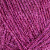 Close-up image of Berroco, Inc.'s Léttlopi (Lite Lopi) Icelandic Wool Yarn in magenta. The yarn appears soft with visible fibers and strands woven together. The texture is slightly fuzzy, suggesting that this Icelandic wool material—perfect for colorwork knitting in durable garments—is well-suited for your next project.